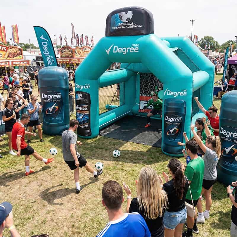 Men kicking soccer balls into inflatable goal